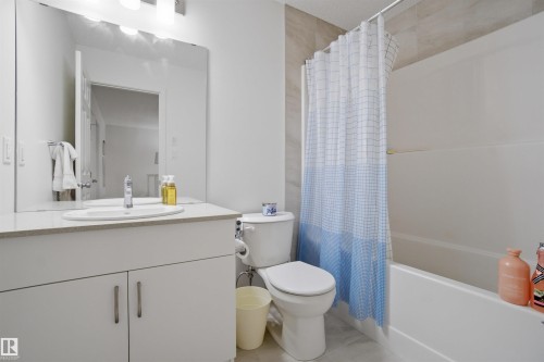 Bathroom featuring shower / bath combo with shower curtain and vanity - 9882 225A St Nw, Edmonton, AB - Indoor Photo Showing Bathroom