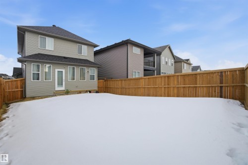 Snow covered house featuring a fenced backyard and a shingled roof - 9882 225A St Nw, Edmonton, AB - Outdoor With Exterior