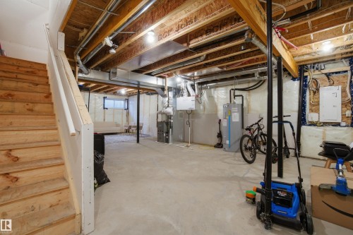 Unfinished basement featuring electric panel, electric water heater, and heating unit - 9882 225A St Nw, Edmonton, AB - Indoor Photo Showing Basement