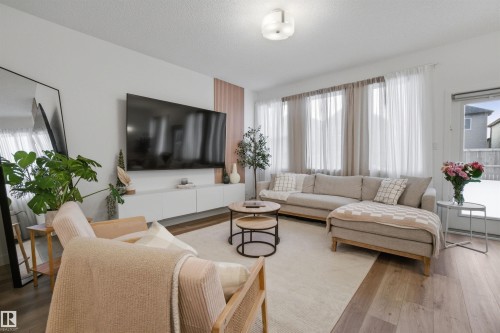 Living area with wood finished floors and a textured ceiling - 9882 225A St Nw, Edmonton, AB - Indoor Photo Showing Living Room