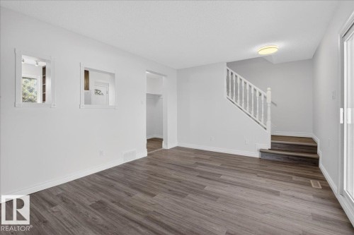 Unfurnished living room featuring wood finished floors and a textured ceiling - 133 Habitat Crescent, Edmonton, AB - Indoor Photo Showing Other Room