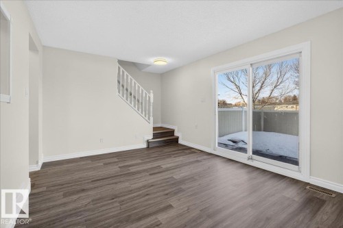 Unfurnished living room with stairway and wood finished floors - 133 Habitat Crescent, Edmonton, AB - Indoor Photo Showing Other Room