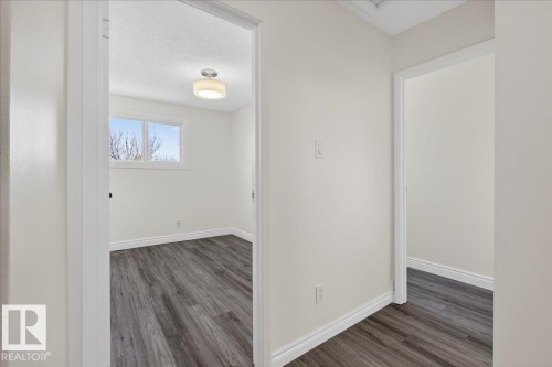 Corridor featuring dark wood-style floors and a textured ceiling - 133 Habitat Crescent, Edmonton, AB - Indoor Photo Showing Other Room