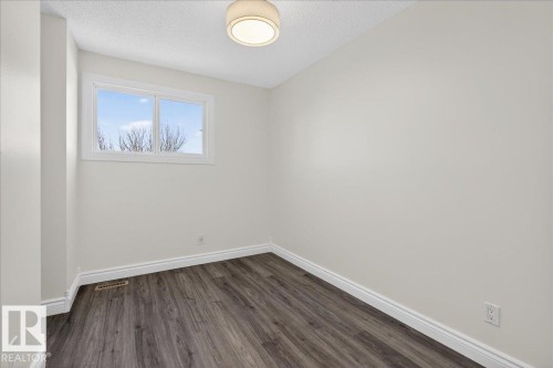 Unfurnished room with dark wood-style floors and a textured ceiling - 133 Habitat Crescent, Edmonton, AB - Indoor Photo Showing Other Room