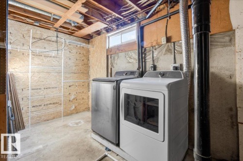 Laundry area featuring concrete flooring and washing machine and clothes dryer - 133 Habitat Crescent, Edmonton, AB - Indoor Photo Showing Laundry Room