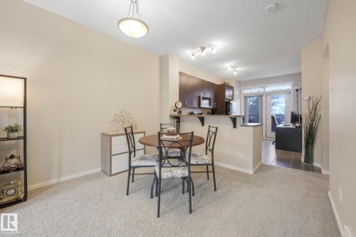 Dining space featuring light carpet, a textured ceiling, and track lighting - 91 603 Watt Boulevard, Edmonton, AB - Indoor Photo Showing Dining Room