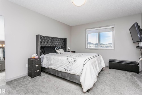 Bedroom featuring a textured ceiling, carpet flooring, and ensuite bath - 2855 16 Avenue, Edmonton, AB - Indoor Photo Showing Bedroom