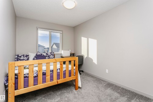 Carpeted bedroom with a textured ceiling and baseboards - 2855 16 Avenue, Edmonton, AB - Indoor Photo Showing Bedroom