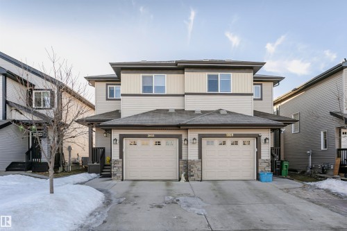 View of front of property with stone siding, concrete driveway, a garage, and a shingled roof - 2855 16 Avenue, Edmonton, AB - Outdoor With Facade