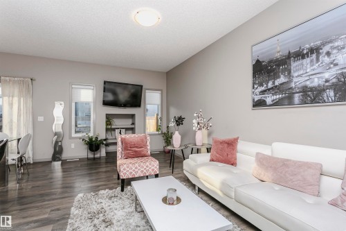 Living room with dark wood-style flooring and a textured ceiling - 2855 16 Avenue, Edmonton, AB - Indoor Photo Showing Living Room With Fireplace