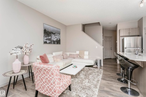Living room with light wood-type flooring and a textured ceiling - 2855 16 Avenue, Edmonton, AB - Indoor