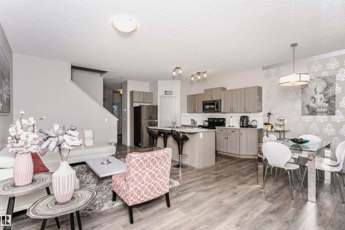 Living area featuring light wood finished floors and a textured ceiling - 2855 16 Avenue, Edmonton, AB - Indoor Photo Showing Other Room