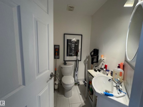 Half bathroom featuring vanity and light tile patterned floors. Located on Main level - 208 178 Bridgeport Boulevard, Leduc, AB - Indoor Photo Showing Bathroom
