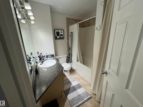 Staircase with a textured ceiling, carpet floors, and a chandelier - 208 178 Bridgeport Boulevard, Leduc, AB - Indoor Photo Showing Other Room