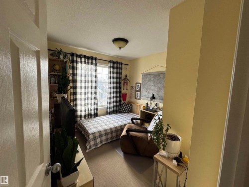 Carpeted bedroom featuring a closet. It is a nice sized room - 208 178 Bridgeport Boulevard, Leduc, AB - Indoor With Fireplace