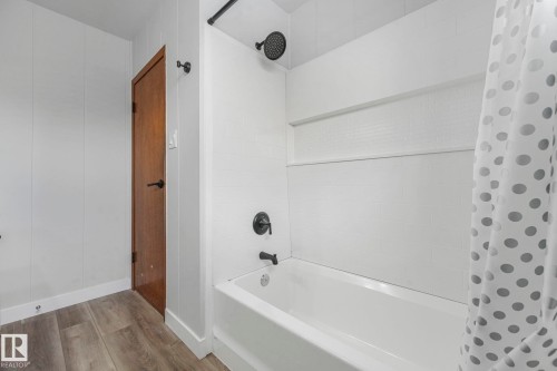 Full bath featuring shower / tub combo with curtain and wood finished floors - 6007 95 Avenue, Edmonton, AB - Indoor Photo Showing Bathroom