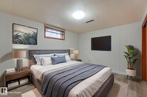 Bedroom with light wood-type flooring and wooden walls - 6007 95 Avenue, Edmonton, AB - Indoor Photo Showing Bedroom