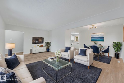 Living area with light wood-style flooring and suspended lighting - 6007 95 Avenue, Edmonton, AB - Indoor Photo Showing Living Room