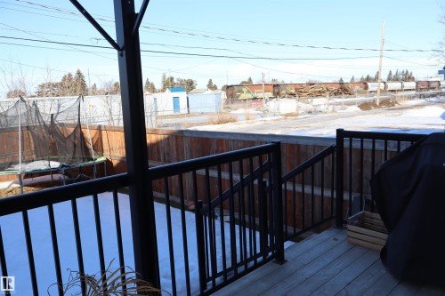 Deck featuring a trampoline, a fenced backyard, grilling area, and a residential view - 9760 - 107 Street, Westlock, AB - Outdoor