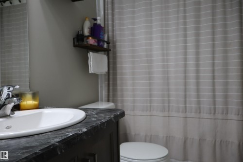 Full bath featuring a shower with shower curtain and vanity - 9760 - 107 Street, Westlock, AB - Indoor Photo Showing Bathroom
