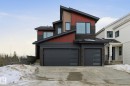 Contemporary home featuring stone siding, driveway, an attached garage, and board and batten siding - 17108 2 Street, Edmonton, AB  - Outdoor With Facade 