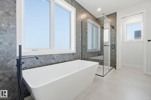 Full bathroom featuring a stall shower, a freestanding tub, and tile walls - 17108 2 Street, Edmonton, AB - Indoor Photo Showing Bathroom