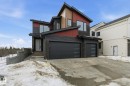 Contemporary house featuring stone siding, driveway, an attached garage, and board and batten siding - 17108 2 Street, Edmonton, AB  - Outdoor 