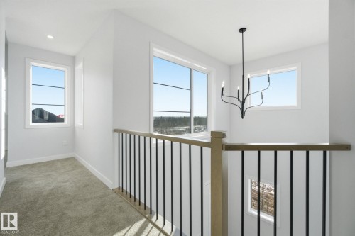 Hall featuring light carpet and suspended lighting - 17108 2 Street, Edmonton, AB - Indoor Photo Showing Other Room