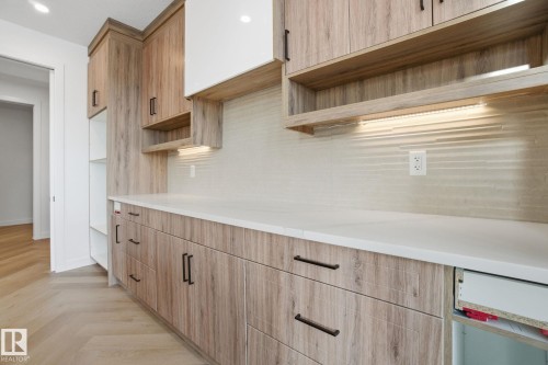 Kitchen with open shelves, parquet floors, backsplash, and light stone countertops - 17107 3 Street, Edmonton, AB - Indoor