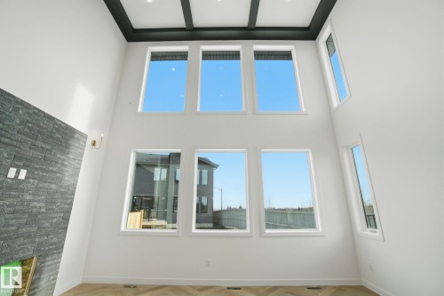 Unfurnished living room with parquet flooring, a fireplace, and a high ceiling - 17107 3 Street, Edmonton, AB - Indoor Photo Showing Other Room