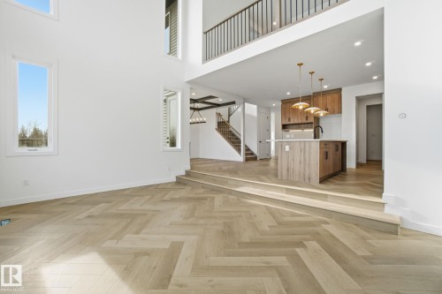Unfurnished living room featuring a high ceiling, parquet flooring, and recessed lighting - 17107 3 Street, Edmonton, AB - Indoor Photo Showing Other Room