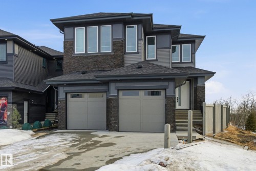 View of front of house with stone siding, roof with shingles, a garage, and driveway - 17107 3 Street, Edmonton, AB - Outdoor With Facade