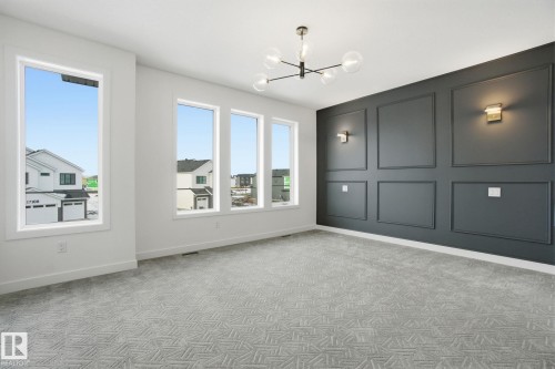 Spare room with a decorative wall, light colored carpet, and a chandelier - 17107 3 Street, Edmonton, AB - Indoor Photo Showing Other Room