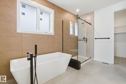 Full bathroom featuring a freestanding tub, a shower stall, and a walk in closet - 17107 3 Street, Edmonton, AB - Indoor Photo Showing Bathroom