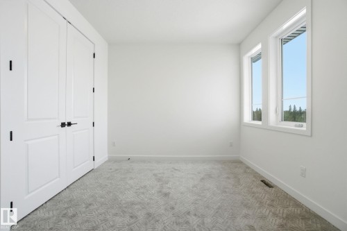 Unfurnished bedroom featuring light colored carpet and a closet - 17107 3 Street, Edmonton, AB - Indoor Photo Showing Other Room