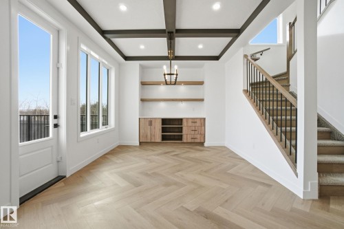 Unfurnished living room featuring coffered ceiling, parquet floors, and a chandelier - 17107 3 Street, Edmonton, AB - Indoor Photo Showing Other Room