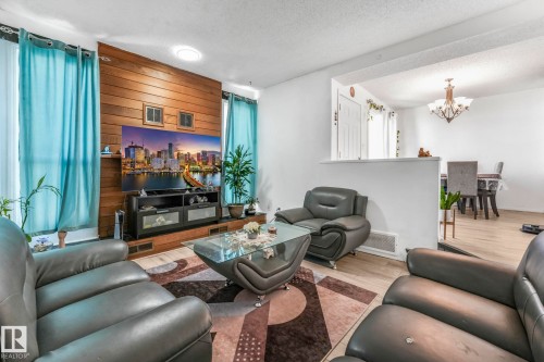 Living area featuring wood finished floors, a textured ceiling, and hanging lights - 19 1415 62 Street, Edmonton, AB - Indoor Photo Showing Living Room