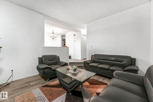 Living room with wood finished floors, a textured ceiling, and a chandelier - 19 1415 62 Street, Edmonton, AB - Indoor Photo Showing Living Room