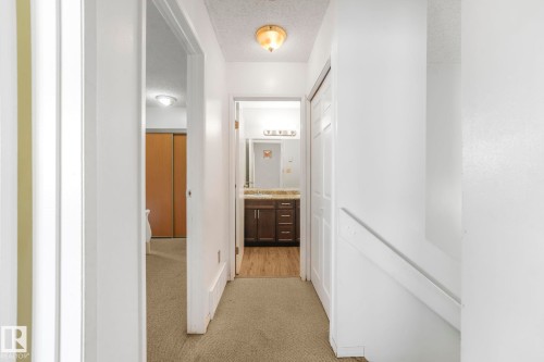 Corridor featuring light carpet and a textured ceiling - 19 1415 62 Street, Edmonton, AB - Indoor Photo Showing Other Room