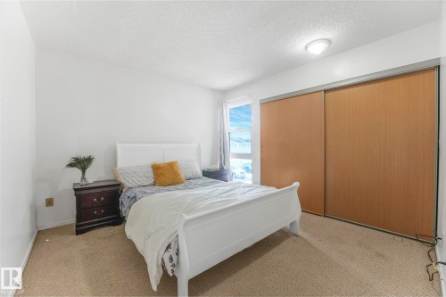 Bedroom with a textured ceiling, light colored carpet, and a closet - 19 1415 62 Street, Edmonton, AB - Indoor Photo Showing Bedroom