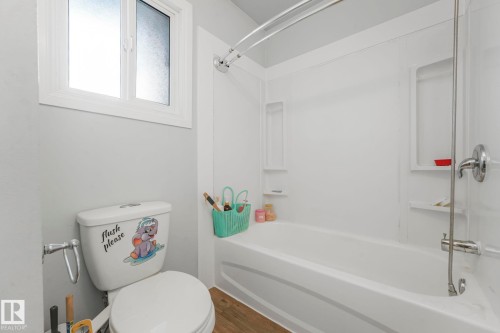 Full bathroom featuring washtub / shower combination and dark wood-style flooring - 19 1415 62 Street, Edmonton, AB - Indoor Photo Showing Bathroom
