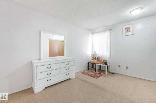 Bedroom featuring a textured ceiling and light colored carpet - 19 1415 62 Street, Edmonton, AB - Indoor
