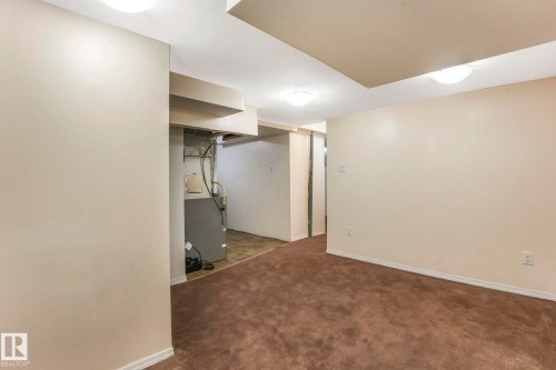 Finished below grade area featuring dark carpet and heating unit - 19 1415 62 Street, Edmonton, AB - Indoor
