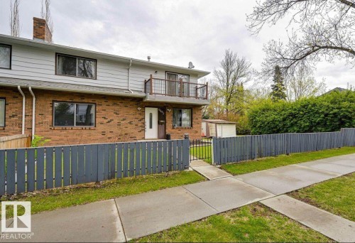 View of front facade with a balcony, brick siding, a fenced front yard, and a chimney - 10602 66 Avenue, Edmonton, AB - Outdoor