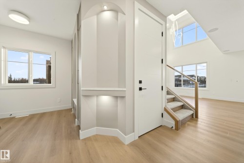 Stairway with a high ceiling, wood finished floors, and plenty of natural light - 8924 Mayday Way, Edmonton, AB 