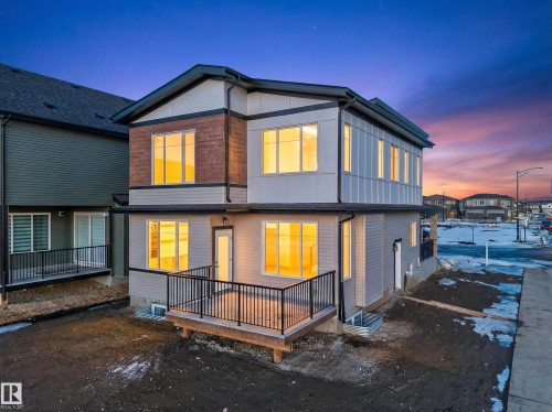 Back of house at dusk with a wooden deck - 8924 Mayday Way, Edmonton, AB 