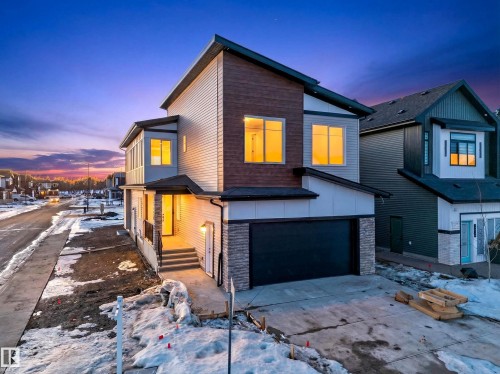 Contemporary house with stone siding, a garage, driveway, and board and batten siding - 8924 Mayday Way, Edmonton, AB 