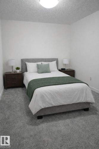 Bedroom featuring light carpet and a textured ceiling - 4513 53 Avenue, Wetaskiwin, AB - Indoor Photo Showing Bedroom