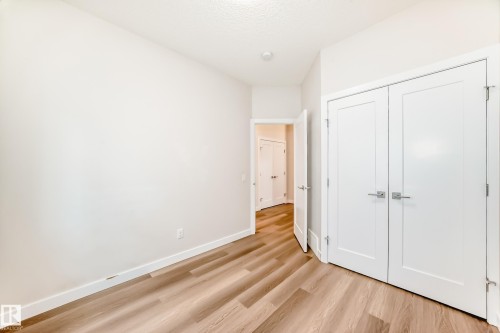 Unfurnished bedroom featuring light wood-style flooring, a closet, and a textured ceiling - 17926 62A Street, Edmonton, AB - Indoor Photo Showing Other Room