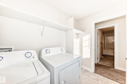 Laundry area featuring washing machine and dryer and baseboards - 17926 62A Street, Edmonton, AB - Indoor Photo Showing Laundry Room